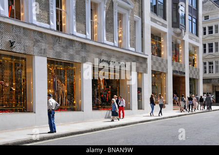 Louis Vuitton davanti al negozio francese di moda di lusso e la finestra decorata mostra il giorno estivo soleggiato in New Bond Street Mayfair West End Londra Inghilterra Regno Unito Foto Stock
