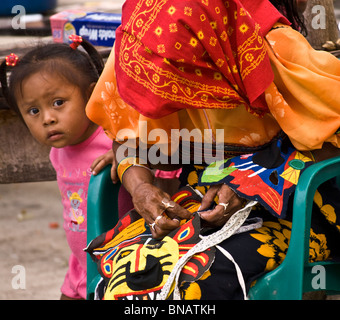 Una chiusura di una Kuna lady cucitura di una mola tradizionale utilizzando i piccoli punti che sono un segno distintivo del loro lavoro. Foto Stock