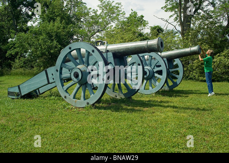 Un visitatore ispeziona una guerra rivoluzionaria il cannone di Colonial National Historical Park presso il Campo di Battaglia di Yorktown nella Storica Yorktown, Virginia, Stati Uniti d'America. Foto Stock