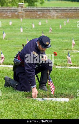 Un Union Army reenactor paga i suoi rispetti presso la tomba di una guerra civile soldato in Yorktown Cimitero Nazionale nella Storica Yorktown, Virginia, Stati Uniti d'America. Foto Stock