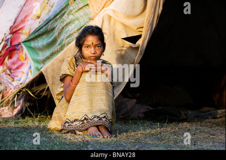 Povero indiano ragazza seduta dentro la sua tenda a casa nella luce del mattino. Andhra Pradesh, India Foto Stock