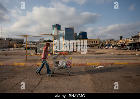 Una tossicodipendente che ha spinto un carro con i suoi effetti personali nel quartiere di neve Shaanan, che è diventato la sede di una delle più grandi popolazioni di africani e di altri migranti nel sud di Tel Aviv Israele Foto Stock