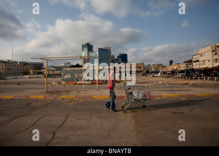 Una tossicodipendente che ha spinto un carro con i suoi effetti personali nel quartiere di neve Shaanan, che è diventato la sede di una delle più grandi popolazioni di africani e di altri migranti nel sud di Tel Aviv Israele Foto Stock