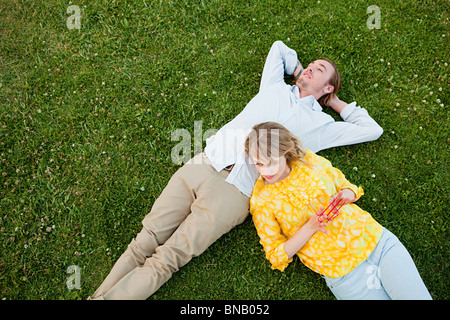 Coppia giovane sdraiato sull'erba Foto Stock