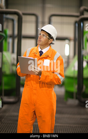 Ingegnere in fabbrica con appunti Foto Stock