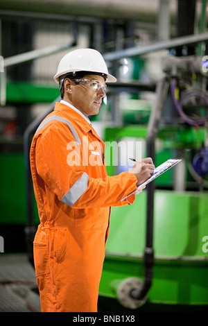 Ingegnere in fabbrica con appunti Foto Stock