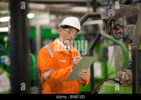 Ingegnere in fabbrica con appunti Foto Stock