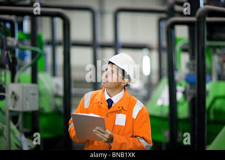 Ingegnere in fabbrica con appunti Foto Stock