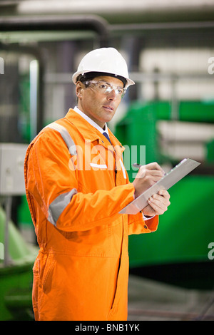 Ingegnere in fabbrica con appunti Foto Stock