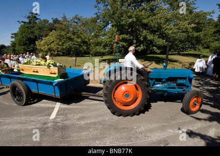 Un'annata 1960 Fordson Dexta trattore tira la bara in un villaggio porcession funebre in Falmer, Sussex England Regno Unito. Foto Stock