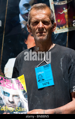 Senzatetto vendendo copie del grande problema rivista, con il motto: "Lavorando non elemosinare', London, Regno Unito Foto Stock