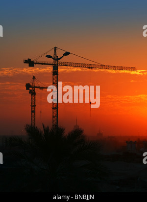 Gru da cantiere su arancione tramonto Cielo Foto Stock