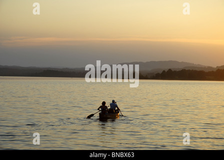 Matura in una barca a remi sul lago al tramonto, Murnau am Staffelsee, Garmisch-Partenkirchen, Alta Baviera, Baviera, Germania Foto Stock