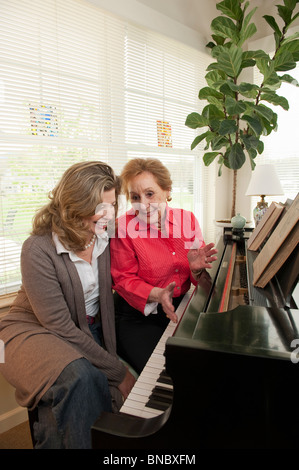 Madre e figlia di parlare al pianoforte Foto Stock