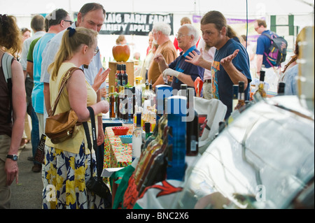 Persone campioni di degustazione del cibo sulle bancarelle a Hay Food Festival in piazza del mercato in Hay-on-Wye Powys Wales UK Foto Stock