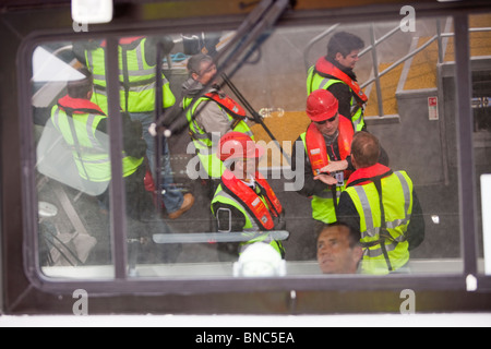 Offshore operai sul modo di Walney Offshore Wind Farm riflessa nella cabina della nave di sostegno. Foto Stock