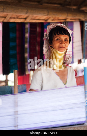 Una donna dalla Padaung lungo collo della tribù della collina e tessitura indossando il tradizionale abito vicino a Tha Ton, Chiang Mai Provincia, Thailandia Foto Stock