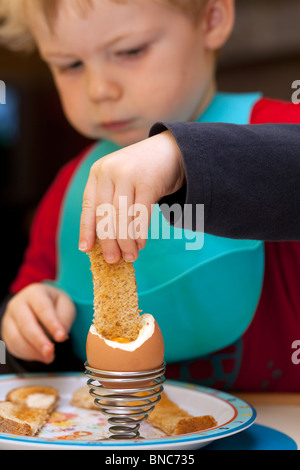 Ragazzo giovane godendo di un uovo sodo. Foto Stock