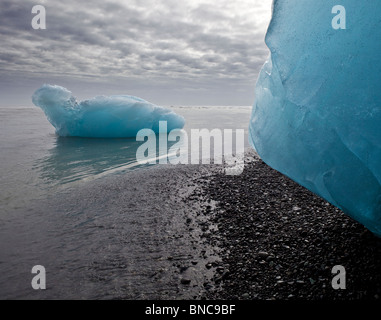 Formazioni di ghiaccio sulla spiaggia di sabbia nera da Breidamerkurjokull ghiacciaio Vatnajokull calotta di ghiaccio, Islanda Foto Stock