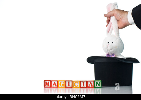 Bambini colorati blocchi del mago di ortografia con un coniglietto coniglio essendo tirato da un cappello a cilindro Foto Stock