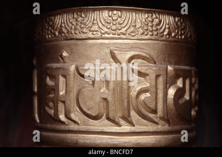 Un oro dipinto ruota di preghiera nel Tashichho Dzong monastero a Thimpu, Bhutan. Foto Stock