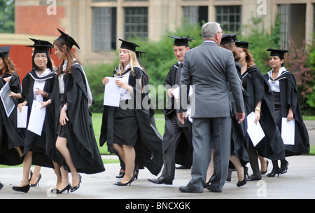 Celebrando laureati presso una università britannica di lasciare la loro cerimonia di laurea con il loro grado di certificati,UK Foto Stock