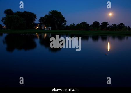 Luna che sorge sopra il lago Foto Stock