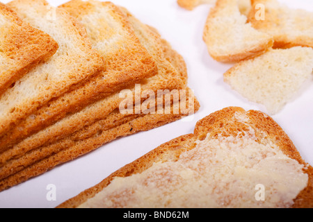 Fette di Melba toast, uno imburrato. Isolato. Foto Stock