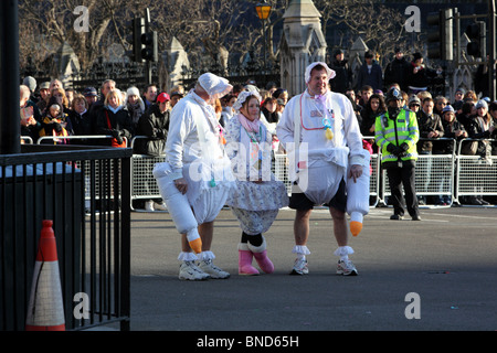 Tre persone vestite come i neonati nella sfilata di Capodanno, Westminster, London, SW1. Foto Stock