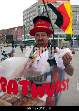 Uomo di vendita Bratwurst tradizionale salsiccia hot dogs dallo stallo mobile a Berlino Germania Foto Stock