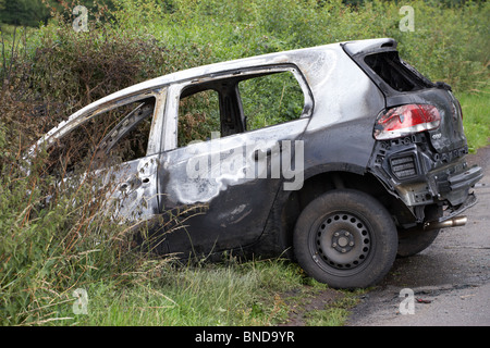 Bruciata rubato Volkswagen golf car si è bloccato in un fossato in Irlanda del Nord nel Regno Unito Foto Stock