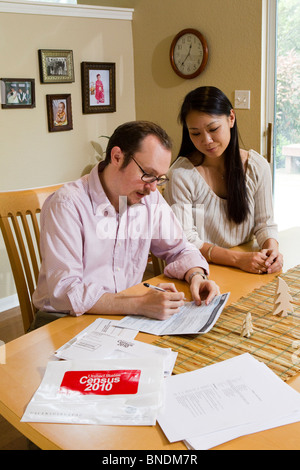 Japanese-American moglie e marito Mexican-American compilare loro 2010 Stati Uniti Censimento forma nella loro casa di Austin, Texas. Foto Stock