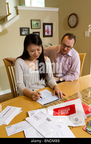 Japanese-American moglie e marito Mexican-American compilare loro 2010 Stati Uniti Censimento forma nella loro casa di Austin, Texas. Foto Stock