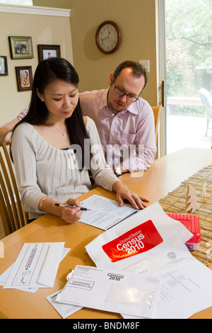 Japanese-American moglie e marito Mexican-American compilare loro 2010 Stati Uniti Censimento forma nella loro casa di Austin, Texas. Foto Stock