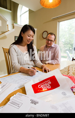 Japanese-American moglie e marito Mexican-American compilare loro 2010 Stati Uniti Censimento forma nella loro casa di Austin, Texas. Foto Stock