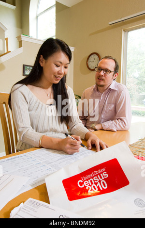 Japanese-American moglie e marito Mexican-American compilare loro 2010 Stati Uniti Censimento forma nella loro casa di Austin, Texas. Foto Stock