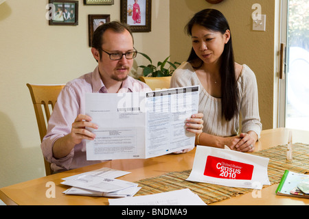 Japanese-American moglie e marito Mexican-American compilare loro 2010 Stati Uniti Censimento forma nella loro casa di Austin, Texas. Foto Stock