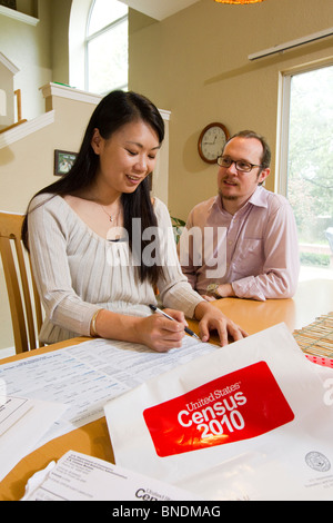 Japanese-American moglie e marito Mexican-American compilare loro 2010 Stati Uniti Censimento forma nella loro casa di Austin, Texas. Foto Stock