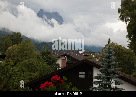 Città di Garmisch-Partenkirchen e montagna Zugspitze che spuntavano dalle nubi nelle Alpi Bavaresi in estate Foto Stock