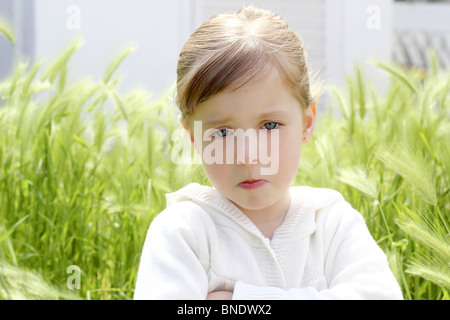 Arrabbiato deluso gesto bambina picchi verde prato giardino Foto Stock