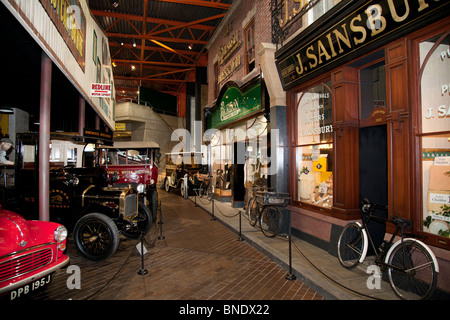 Scena di strada con negozi,automobili e biciclette di consegna in Beaulieu Motor Museum. Foto Stock