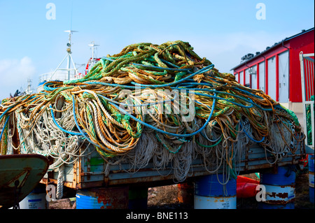 Vecchio rimorchio in legno riempita con corde in piedi sul barili arrugginiti nel porto di Uusikaupunki, Finlandia Foto Stock