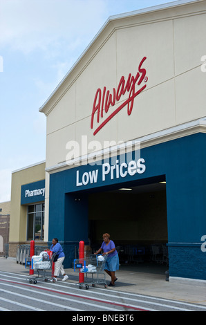 Due donne spingendo il carrello al di fuori della Wal-Mart super di ingresso al centro di Houston, Texas, Stati Uniti d'America Foto Stock