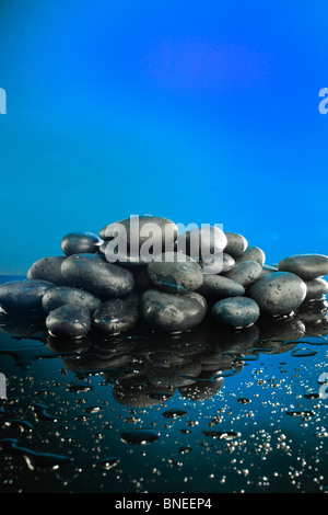 Wet pietre di fiume sul tramonto come sfondo Foto Stock