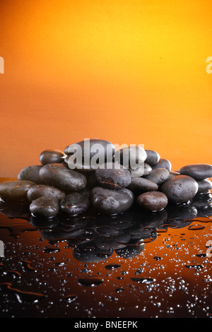 Wet pietre di fiume sul tramonto come sfondo Foto Stock