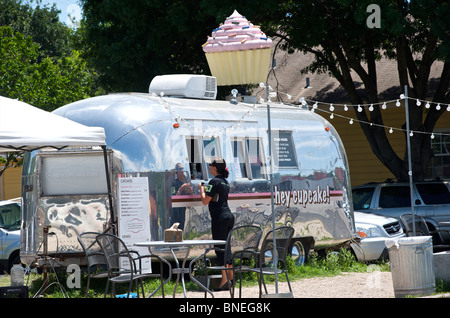 Donna in piedi nella parte anteriore del rimorchio alla moda tortini di vendita da in Austin, Texas, Stati Uniti d'America Foto Stock