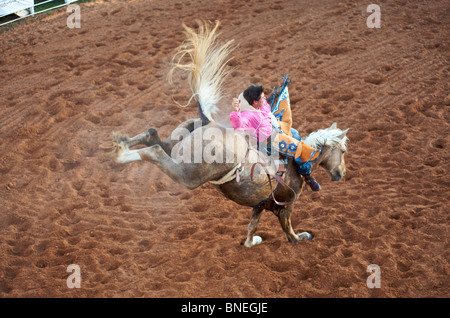 Cavallo cercando di gettare il rodeo cowboy membro di PRCA dalla sua parte posteriore in Texas Smalltown Bridgeport Foto Stock