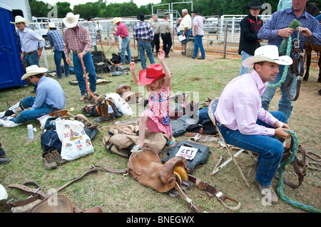 Sei giovani anno cowgirl correre e saltare oltre i cowboys di PRCA Rodeo in backstage a Smalltown, Bridgeport, STATI UNITI D'AMERICA Foto Stock