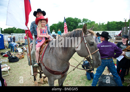 Sei giovani anno cowgirl in posa sul cavallo a PRCA Rodeo a Smalltown, Bridgeport, Texas, Stati Uniti d'America Foto Stock