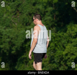 Un maschio di uomo a camminare nel parco. Foto Stock